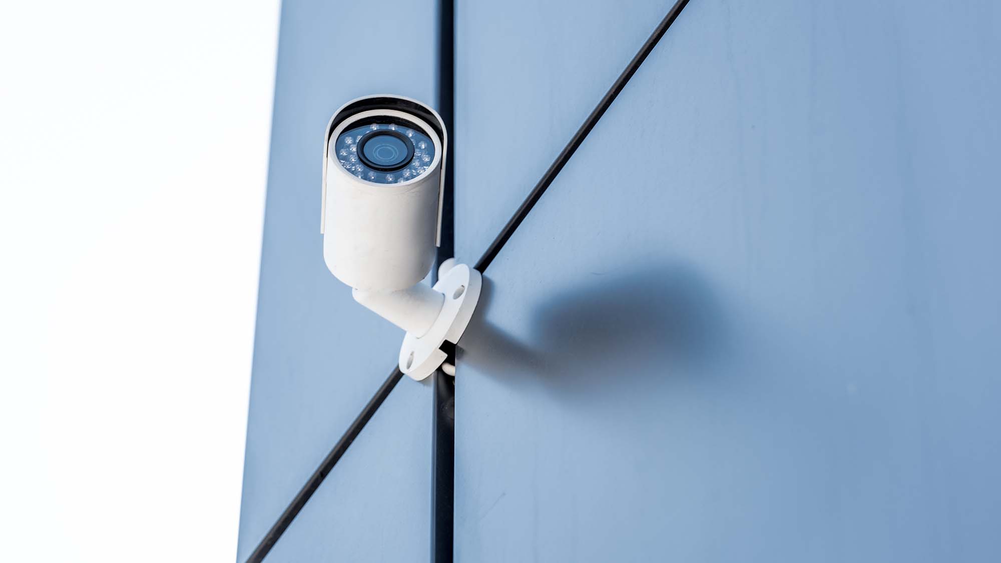 Bullet-style CCTV camera mounted on the exterior wall of a commercial building